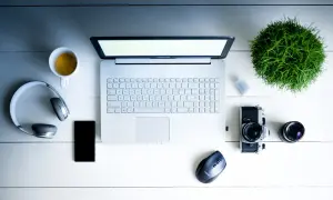 Na biurku leżą laptop, słuchawki, telefon, aparat i kawa. Zastanawiasz się, middleware co to? To oprogramowanie łączące różne systemy.