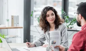 Kobieta i mężczyzna omawiają wykresy w nowoczesnym biurze, symbolizując efektywny digital workplace.