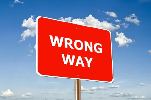 Czerwony znak "WRONG WAY" na tle błękitnego nieba z chmurami. Uważaj, by nie popełnić błędów podczas wdrożenia SAP.