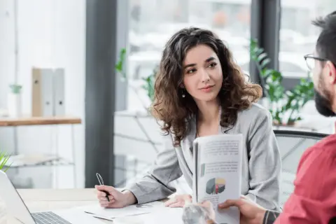 Kobieta i mężczyzna omawiają wykresy w nowoczesnym biurze, symbolizując efektywny digital workplace.
