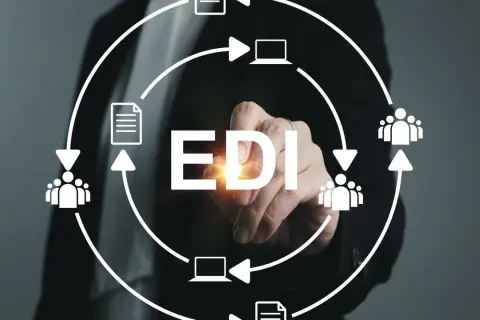 Ręka dotyka napisu EDI, symbolizując elektroniczną wymianę danych między firmami, z ikonami dokumentów, ludzi i komputerów w obiegu.