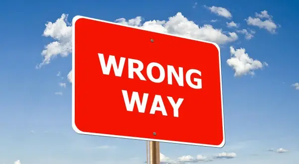 Czerwony znak "WRONG WAY" na tle błękitnego nieba z chmurami. Uważaj, by nie popełnić błędów podczas wdrożenia SAP.