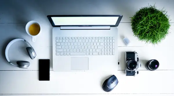 Na biurku leżą laptop, słuchawki, telefon, aparat i kawa. Zastanawiasz się, middleware co to? To oprogramowanie łączące różne systemy.