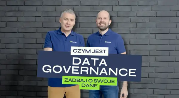 Dwóch mężczyzn w koszulkach z logo Netige prezentuje tablicę z napisem "CZYM JEST DATA GOVERNANCE ZADBAY O SWOJE DANE", podkreślając znaczenie zarządzania danymi.