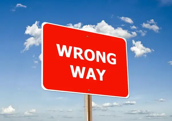 Czerwony znak "WRONG WAY" na tle błękitnego nieba z chmurami. Uważaj, by nie popełnić błędów podczas wdrożenia SAP.