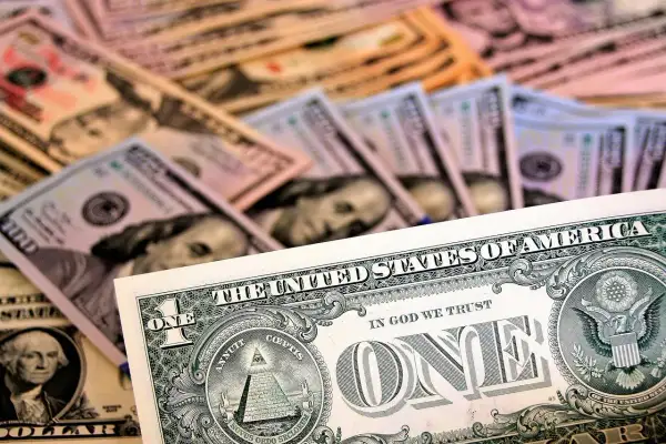 Stos banknotów dolarowych, w tym jeden dolar z piramidą i oko opatrzności, tworzy tło dla biznesu, gdzie infatica p2b jest kluczowa.