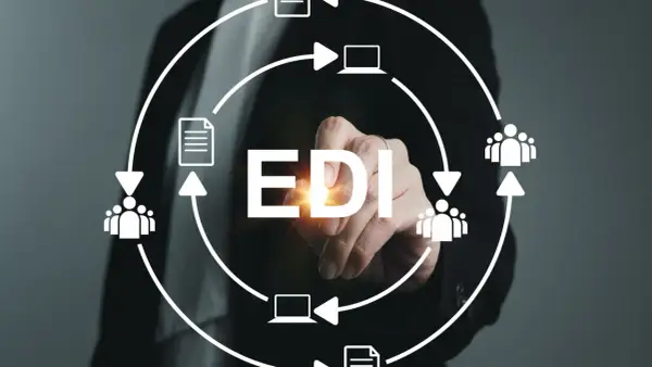 Ręka dotyka napisu EDI, symbolizując elektroniczną wymianę danych między firmami, z ikonami dokumentów, ludzi i komputerów w obiegu.